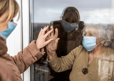 mother and daughter with masks behind door