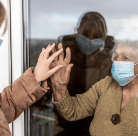 mother and daughter with masks behind door