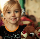 little girl holding a stuffed reindeer